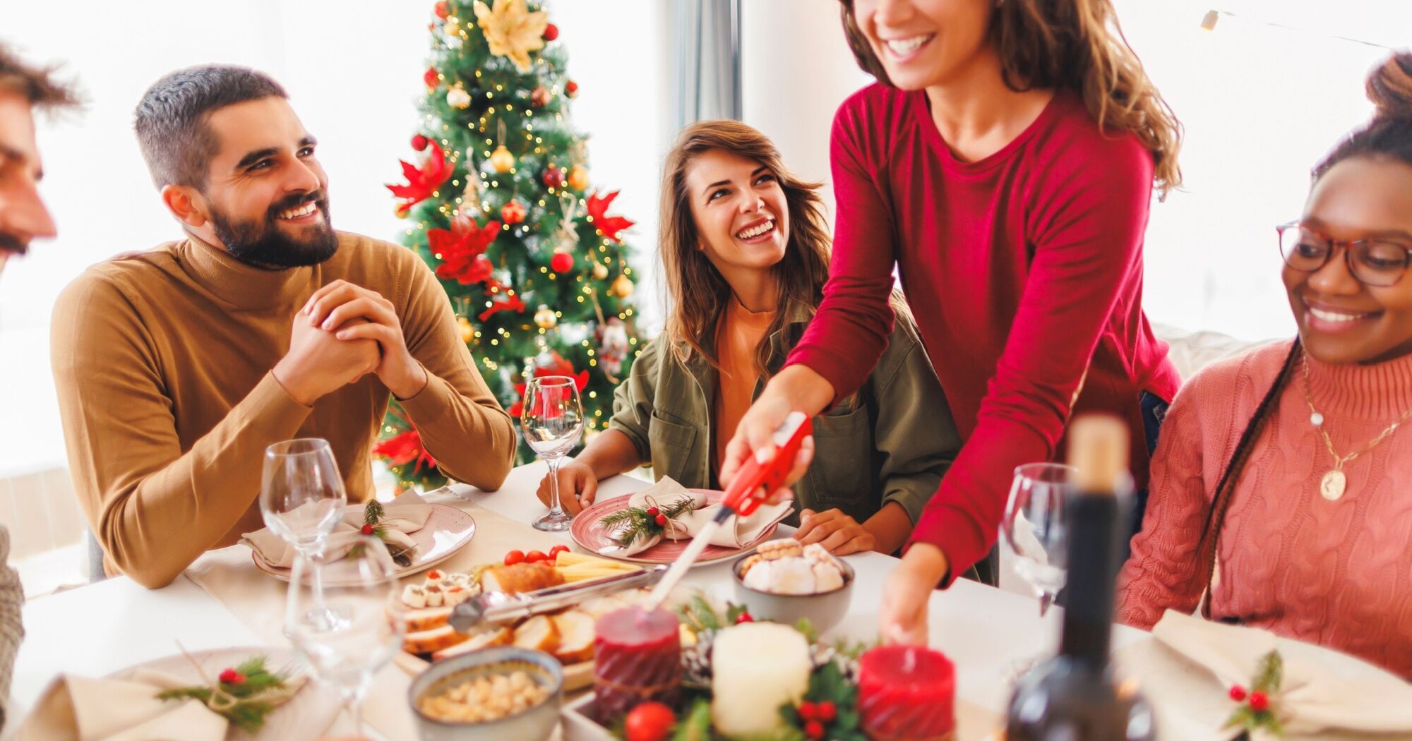 Festive gathering in a beautifully designed home with a Christmas tree, elegant table settings, and cheerful holiday decor—perfect for entertaining guests during the holiday season.